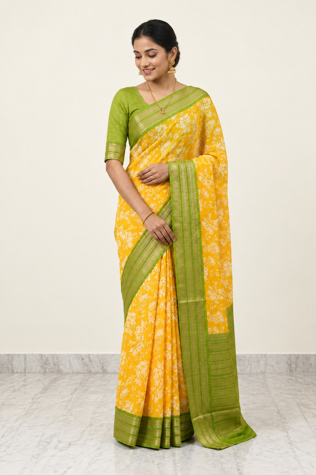 Woman wearing a yellow and green saree on a plain background